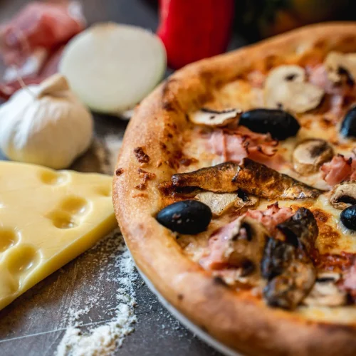 Pizza Capriciosa cu șuncă, ciuperci și sardine + Pizzeria Mama Mia – Rețete italiene autentice. Livrare GRATUITĂ în Timișoara și comunele din jur.